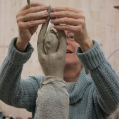 Teilnehmende modellieren Figuren aus Ton im Atelier